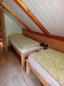 two beds in a attic room with wooden floors at Chata Gerlinda in Kašperské Hory