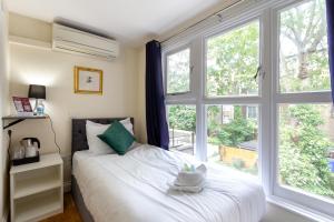 a bedroom with a bed and a large window at Coronation Hotel in London