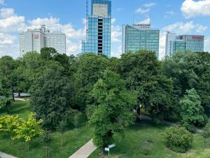 un parque con árboles frente a una ciudad en Andersia Park en Poznan