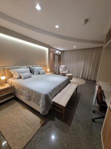 a large bedroom with a large bed and chairs at Lindóya Hotel in Catalão