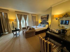 ein Hotelzimmer mit einem Schlafzimmer mit einem Bett und einem Klavier in der Unterkunft Harte and Garter Hotel in Windsor