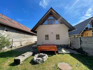 una casa con un banco de madera en el patio en Chata EVA v krásnej dedinke, en Závadka nad Hronom