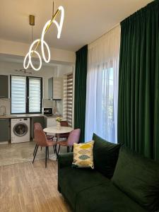a living room with a green couch and a table at sicanT Apartments - Self Check-in in Constanţa