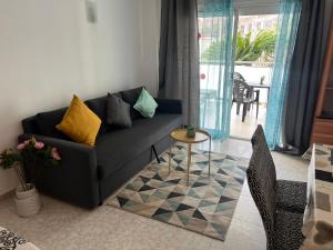 ein Wohnzimmer mit einer schwarzen Couch und einem Tisch in der Unterkunft Clear Water Beach Apartments in Salou