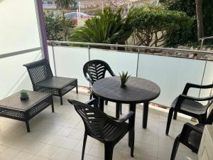eine Terrasse mit Tisch und Stühlen auf einem Balkon in der Unterkunft Clear Water Beach Apartments in Salou