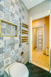ein Bad mit WC und eine Tür zu einem Flur in der Unterkunft Azure Resident Apartments in Baku