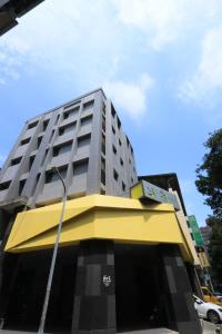 a tall building with a yellow and gray top at 逢甲25行館Fengjia 25 Hotel in Taichung