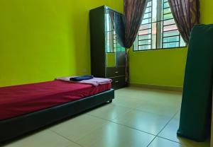 a green room with a bed and a window at IRDINA HOMESTAY forMuslims - Changlun in Changlun