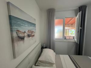 una camera con un letto e un dipinto di barche di Marko Beachfront Apartments Seget Trogir a Trogir Altre 104 foto