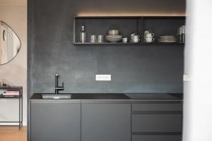 a kitchen with a sink and a shelf with dishes at LUXE VISTA City Apartments Algund in Lagundo +68 photos