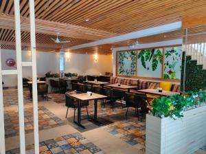 a restaurant with wooden ceilings and tables and chairs at Hotel Rose Dale in Bhowāli