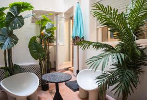 Pokój z dwoma białymi krzesłami i roślinami w obiekcie Suites You Zinc w Madrycie