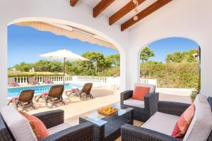 an outdoor patio with wicker furniture and a swimming pool at Villa Nero by Villa Plus in Son Parc