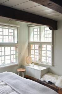 - une chambre avec un lit, un lavabo et 2 fenêtres dans l'établissement Huis met de Kogel, à Alkmaar