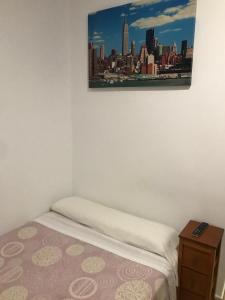 a bedroom with a bed and a picture on the wall at Pensión LF No Fumadores - Sin Ascensor in Zaragoza
