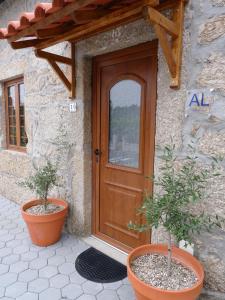 een deur van een huis met twee potplanten voor de deur bij Casa da Rabita in Capinha