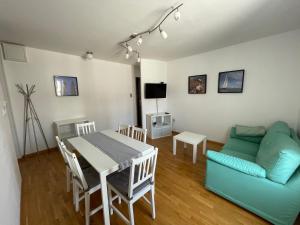 a living room with a blue couch and a table at Apartment Tartini in Piran