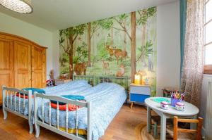 Un dormitorio con una cama y un cuadro en la pared. en Le verger, en Rouilly-Sacey