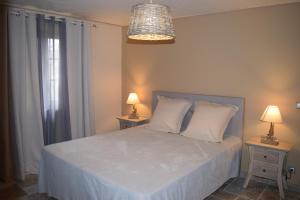 Un dormitorio con una cama blanca con dos mesitas de noche. en Chambre Périgourdine, en Beynac-et-Cazenac