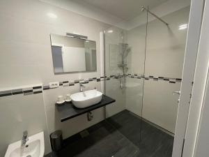 a bathroom with a sink and a glass shower at Apartment Tartini in Piran +7 photos