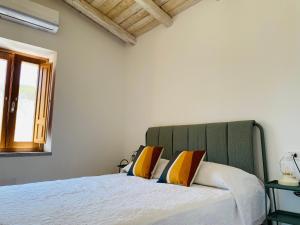 a bedroom with a white bed with a green headboard at Villa Case Vecchie in La Murta