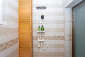 a bathroom with a shower with two bottles of wine at 渔月撸猫客栈-大理古城店 in Dali