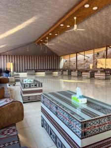 een grote lobby met een tafel in het midden van een kamer bij Traditions of Wadi Rum camp & jeep tour in Wadi Rum