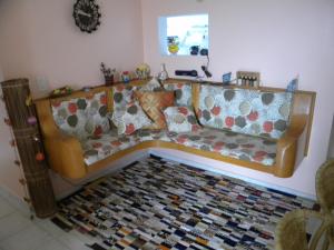 un sofá en una sala de estar con alfombra en Apartamento Chile, en Guarujá