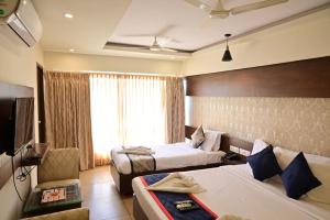 a hotel room with two beds and a couch at Canyon sun in Chennai