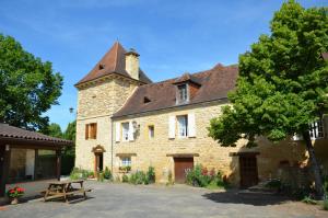 a large stone building with a clock tower at Chambre Périgourdine in Beynac-et-Cazenac