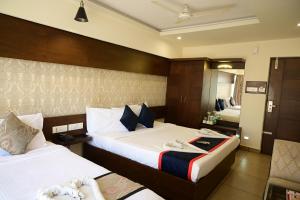 a hotel room with two beds and a mirror at Canyon sun in Chennai
