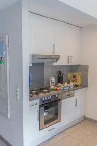 a kitchen with white cabinets and a stove top oven at Ferienhaus Ostsee in Pruchten