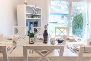a dining room table with two bottles of wine on it at Ferienhaus Ostsee in Pruchten +26 photos