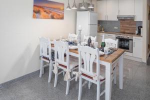 a kitchen with a dining room table with white chairs at Ferienhaus Kranich in Pruchten