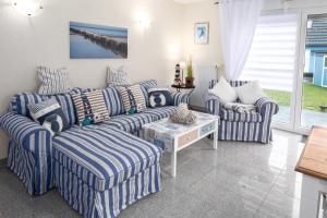 a living room with blue and white striped couches and a table at Ferienhaus Kranich in Pruchten +27 photos