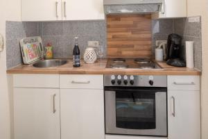 a kitchen with white cabinets and a stove and a sink at Ferienhaus Kranich in Pruchten