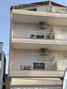 a building with two balconies and a sign on it at INFINITY Center Apartment in Nea Kallikrateia