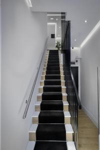 una escalera en una casa con escaleras blancas y negras en Haven heights international, en Blackpool