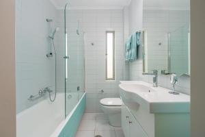 Vouliagmeni - Apollonos Street في أثينا: حمام مع حوض ومرحاض ودش