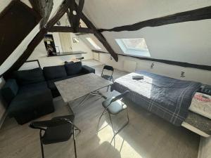Un dormitorio con una cama y una mesa y sillas. en La Maison Gauloise - Asterix CDG Paris, en La Chapelle-en-Serval 27 fotos más