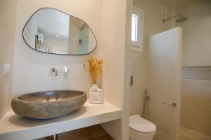 a bathroom with a large stone sink and a mirror at Sea sound in Mylopotas +52 photos