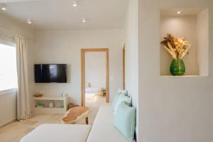 a living room with a white couch and a vase of flowers at Sea sound in Mylopotas