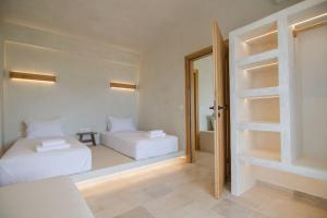a bedroom with two beds and a mirror in it at Sea sound in Mylopotas