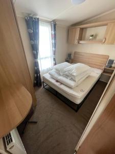 リルにあるLyons robin hood caravan 43SWの窓のある小さな部屋にある小さなベッド