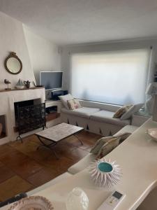 een woonkamer met een bank en een open haard bij Villa Bianca, piscina e panorama in Torre delle Stelle