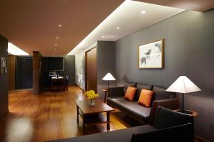 a living room with a couch and a table at Oriens Hotel & Residences Myeongdong in Seoul