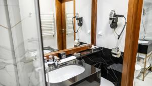 a bathroom with a sink and a mirror at Hotel Czarny Potok Resort SPA & Conference in Krynica Zdrój
