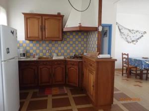 a kitchen with wooden cabinets and a white refrigerator at Maison confortable à Saint-Hilaire-de-Riez avec jardin clôturé in Saint-Hilaire-de-Riez