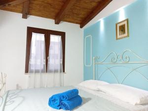 a bedroom with a bed with two blue towels on it at Residenza Degli Dei in Tropea