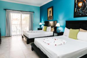 2 camas en una habitación con paredes azules en Hotel Brisa en Punta Cana